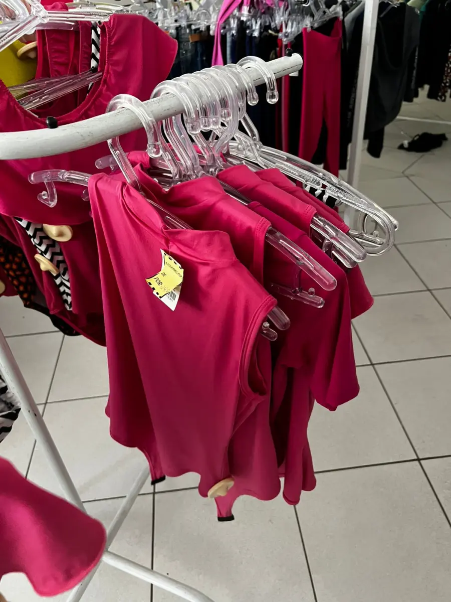 LOTE 000 - Lote com aproximadamente 3.500 peças de roupas e seus cabides (toda a loja): vestidos, saias, moletons, casacos, bermudas, calças, camisetas