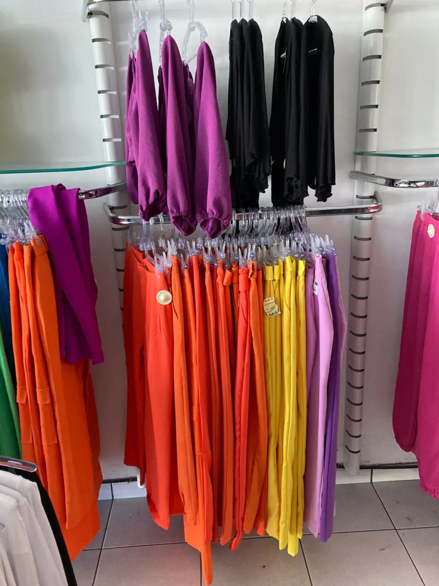 LOTE 000 - Lote com aproximadamente 3.500 peças de roupas e seus cabides (toda a loja): vestidos, saias, moletons, casacos, bermudas, calças, camisetas