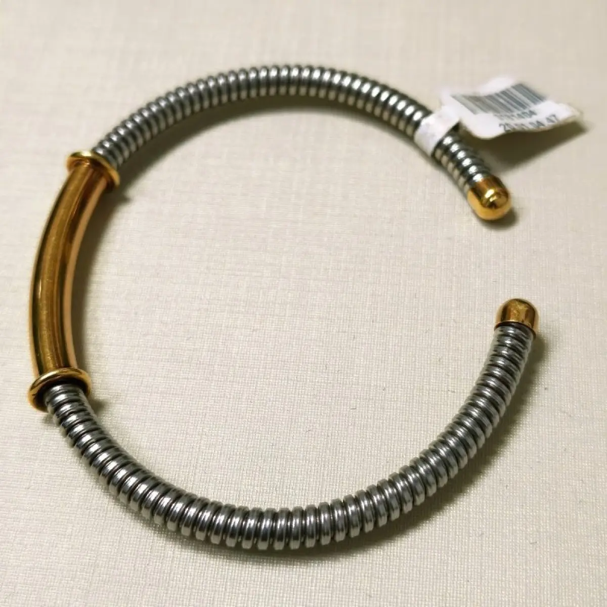 LOTE 003 - Uma pulseira, estilo cabo, com as ponteiras, adereço central em ouro amarelo