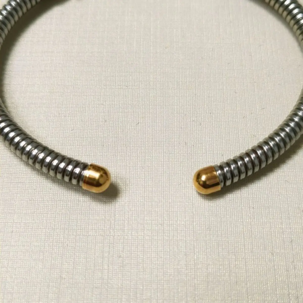 LOTE 003 - Uma pulseira, estilo cabo, com as ponteiras, adereço central em ouro amarelo