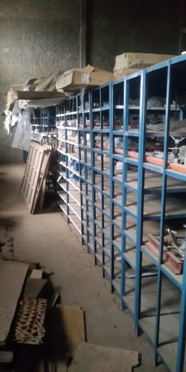 LOTE 5 - Lote de prateleiras metálicas com peças de reposição para veículos, peças de manutenção, partes de carro, tais como: para-choques, capôs de carro, correias, parafusos, porcas, tapetes de carro, painéis plásticos, aros de rodas pneus, partes de lataria de carros, lanternas, etc, aval.: R$ 55.000,00