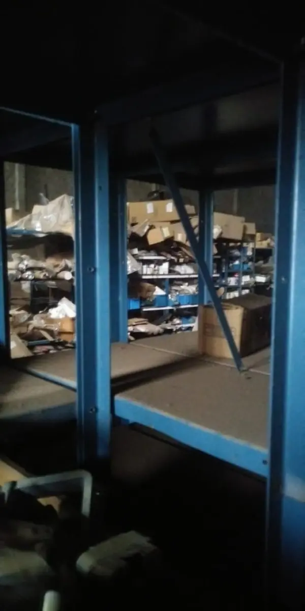 LOTE 5 - Lote de prateleiras metálicas com peças de reposição para veículos, peças de manutenção, partes de carro, tais como: para-choques, capôs de carro, correias, parafusos, porcas, tapetes de carro, painéis plásticos, aros de rodas pneus, partes de lataria de carros, lanternas, etc, aval.: R$ 55.000,00