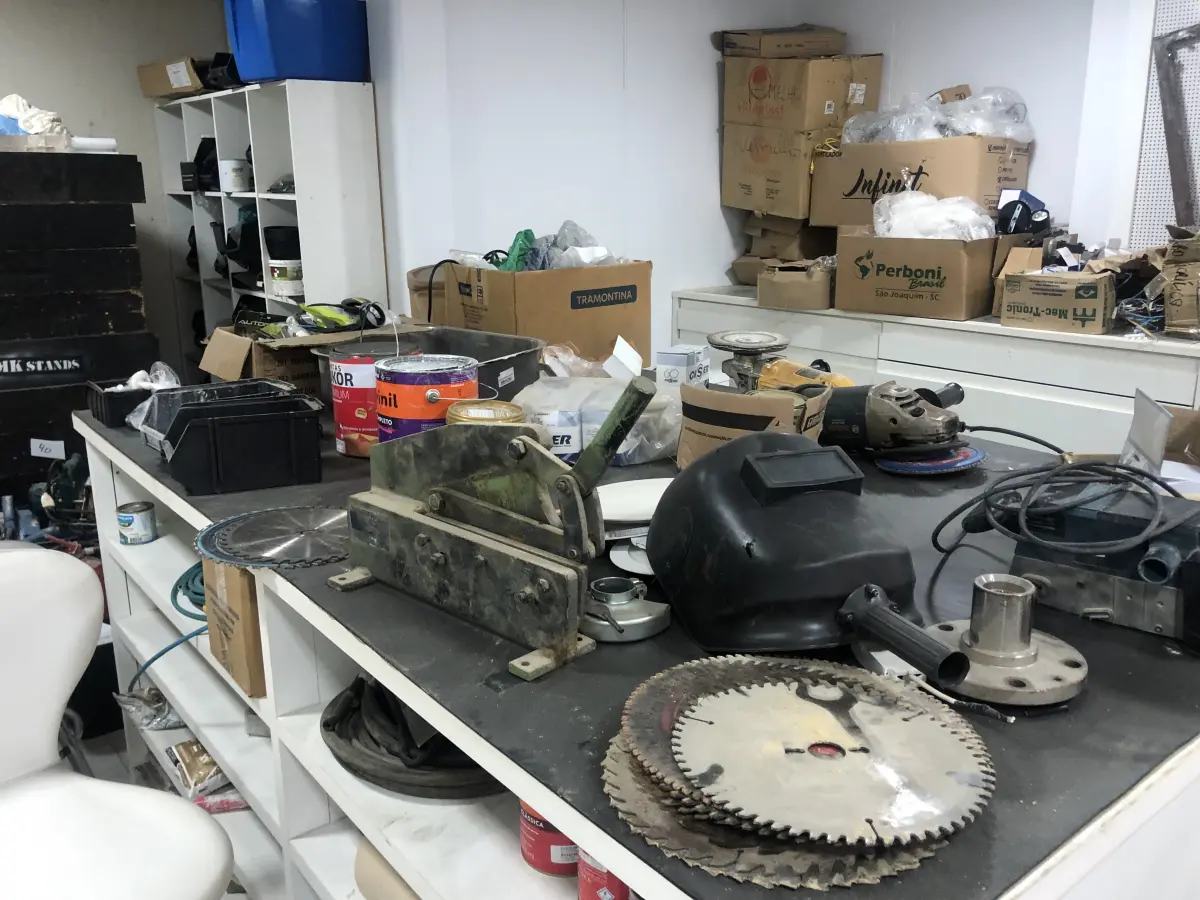 LOTE 046 - Lote com guilhotina, esmerilhadeiras, serras, parafusos, banquetas, manequim, catalogos, cortinas, fitas de borda, serra circular, lixadeiras, engraxadeira, cones, cintas, catracas, vaso, cintos alpinista, prateleira, balcão, armarios, silicones, soprador de calor, etc 