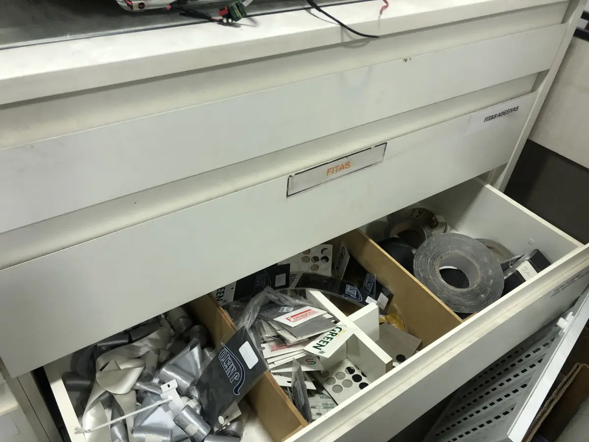 LOTE 046 - Lote com guilhotina, esmerilhadeiras, serras, parafusos, banquetas, manequim, catalogos, cortinas, fitas de borda, serra circular, lixadeiras, engraxadeira, cones, cintas, catracas, vaso, cintos alpinista, prateleira, balcão, armarios, silicones, soprador de calor, etc 