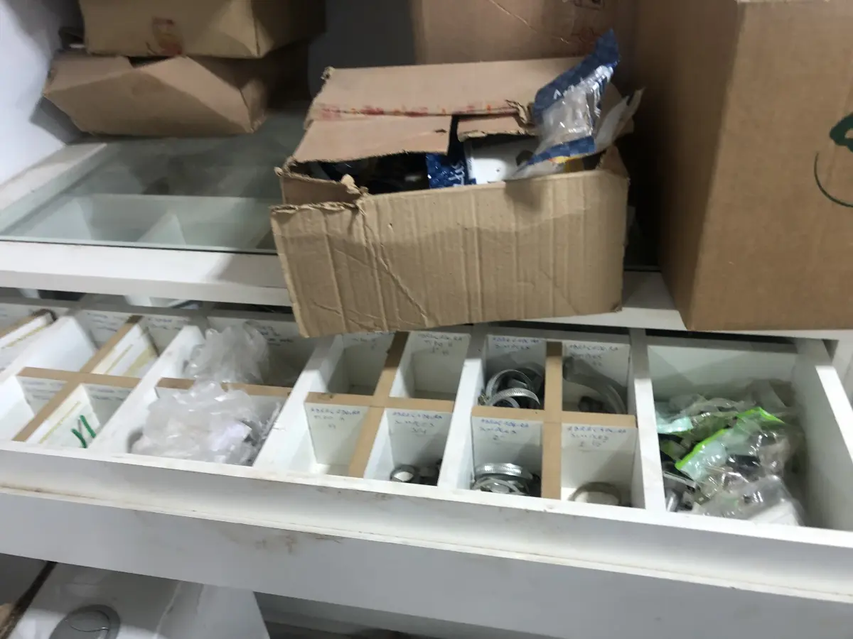 LOTE 046 - Lote com guilhotina, esmerilhadeiras, serras, parafusos, banquetas, manequim, catalogos, cortinas, fitas de borda, serra circular, lixadeiras, engraxadeira, cones, cintas, catracas, vaso, cintos alpinista, prateleira, balcão, armarios, silicones, soprador de calor, etc 