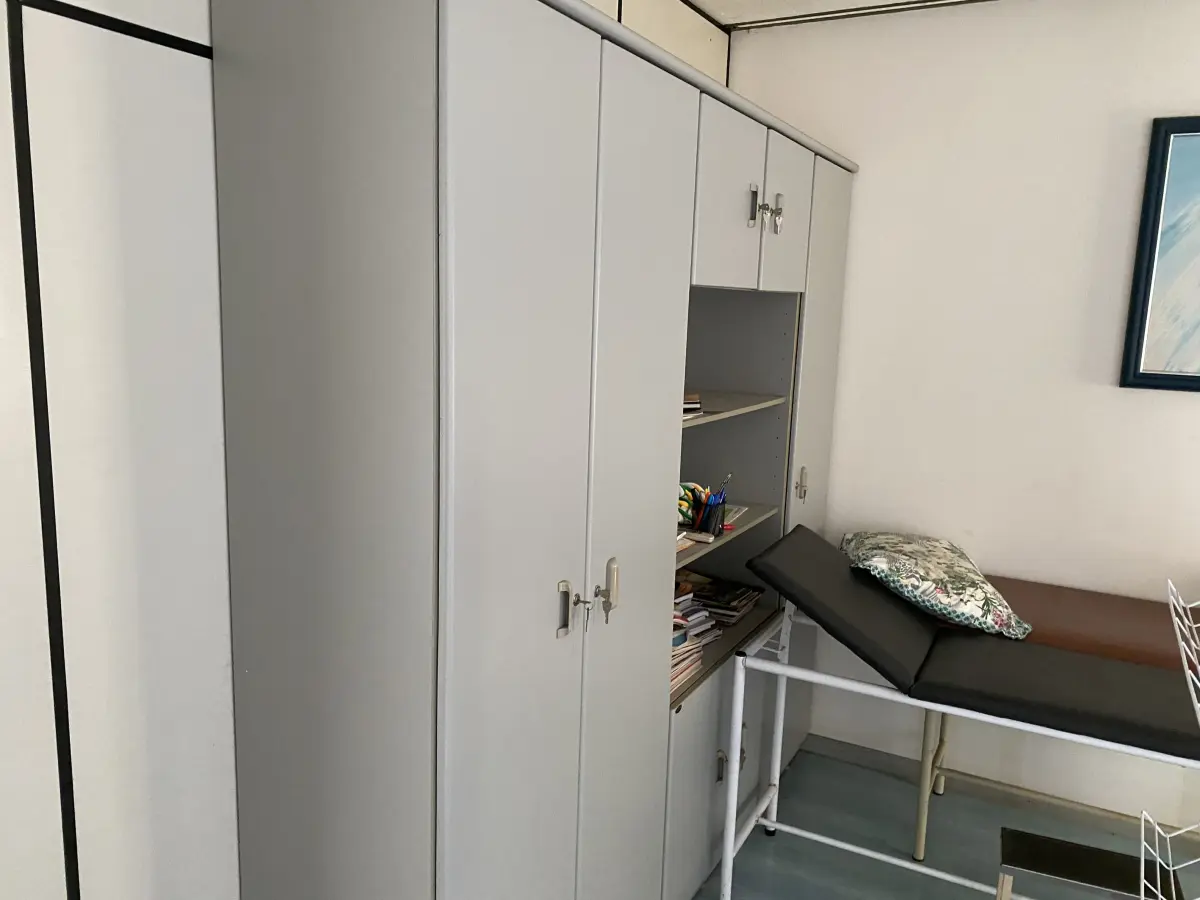 LOTE 515 - Armario de madeira, 2 macas, ar condicionado, quadro, balança, mesa e 2 cadeiras , armario portas de vidro 