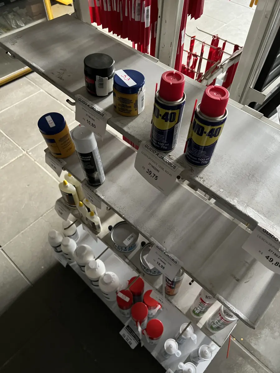 LOTE 033 - Lote com WD-40, cola para madeira, espuma de polioretano, silicone, movel expositor 