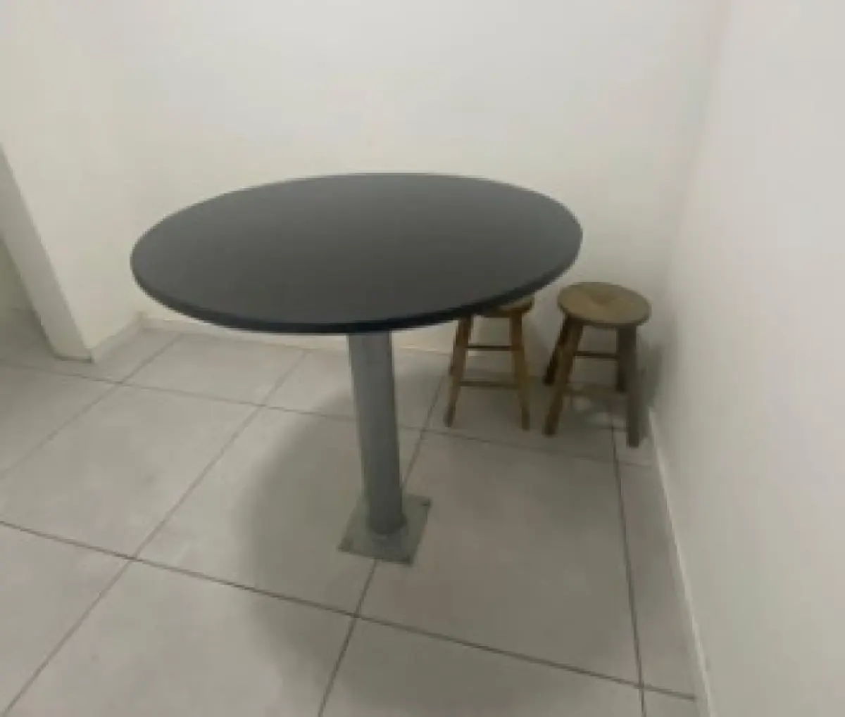 LOTE 040 - 1 mesa com tampo de mármore negro pregada ao chão