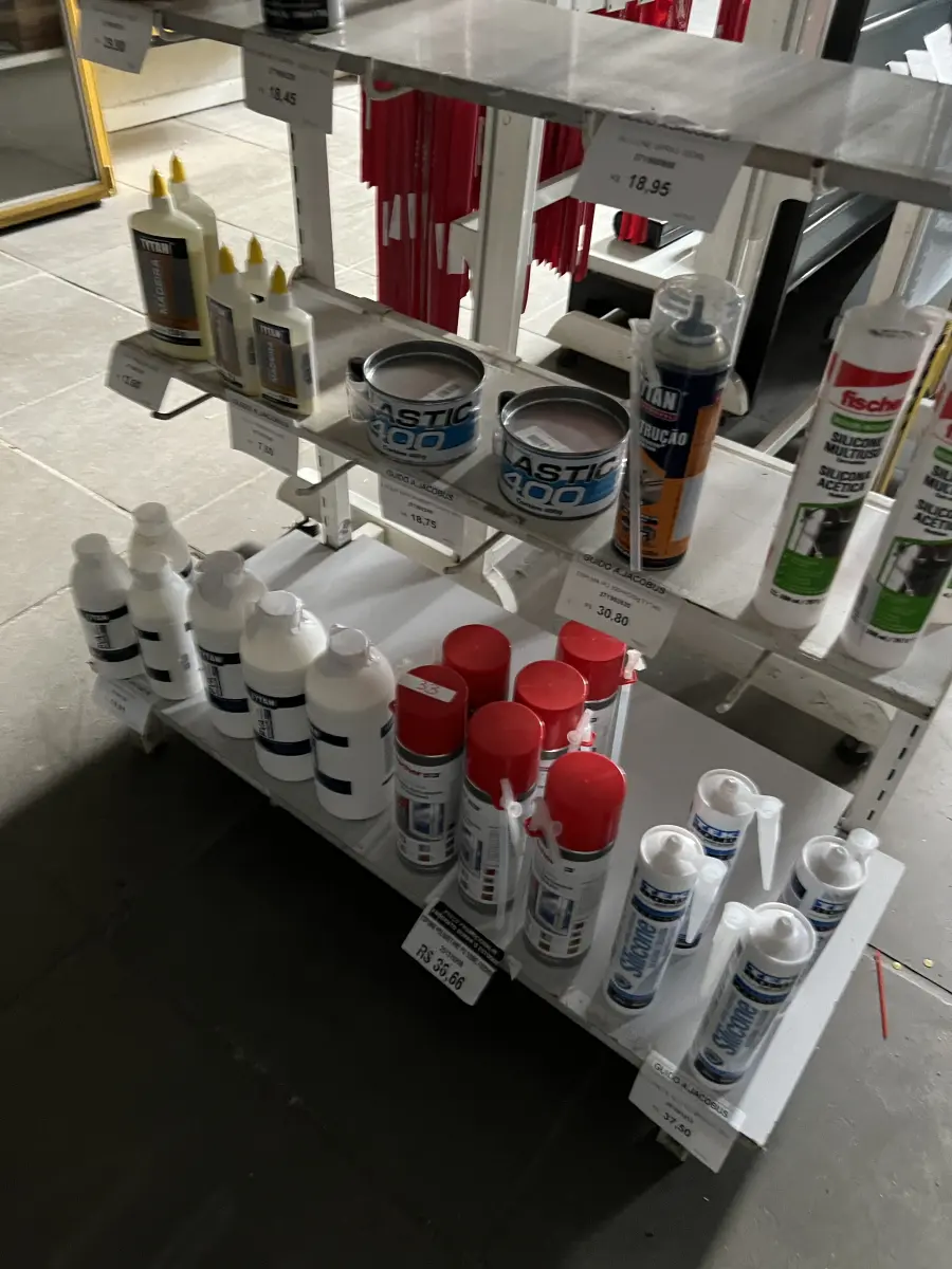 LOTE 033 - Lote com WD-40, cola para madeira, espuma de polioretano, silicone, movel expositor 