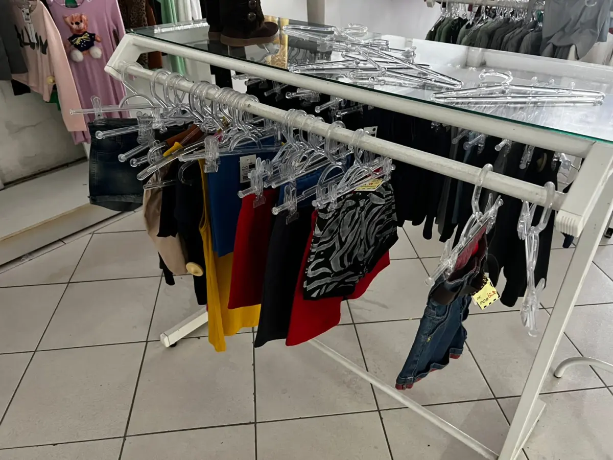 LOTE 000 - Lote com aproximadamente 3.500 peças de roupas e seus cabides (toda a loja): vestidos, saias, moletons, casacos, bermudas, calças, camisetas