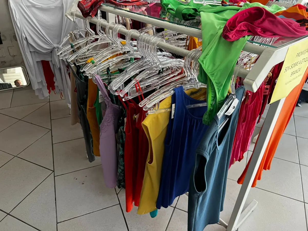 LOTE 000 - Lote com aproximadamente 3.500 peças de roupas e seus cabides (toda a loja): vestidos, saias, moletons, casacos, bermudas, calças, camisetas