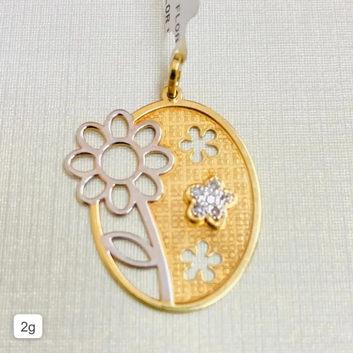 LOTE 003 - Pingente: Modelo chapa vazado, flor com diamantes, 6 pedras de diamantes. Ouro amarelo e branco de 18k. Código 697249