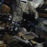 LOTE 5 - Lote de prateleiras metálicas com peças de reposição para veículos, peças de manutenção, partes de carro, tais como: para-choques, capôs de carro, correias, parafusos, porcas, tapetes de carro, painéis plásticos, aros de rodas pneus, partes de lataria de carros, lanternas, etc, aval.: R$ 55.000,00