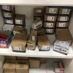 LOTE 046 - Lote com guilhotina, esmerilhadeiras, serras, parafusos, banquetas, manequim, catalogos, cortinas, fitas de borda, serra circular, lixadeiras, engraxadeira, cones, cintas, catracas, vaso, cintos alpinista, prateleira, balcão, armarios, silicones, soprador de calor, etc 