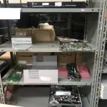 LOTE 348 - Armario 2 portas, prateleira com placas, mesa com bancada, prateleira com antenas, rack de equipamentos de teste, roteadores, carrinhos 