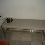 LOTE 012 - armário com 2 portas de abris e 2 prateleiras cor marrom e um banco de espera cinza
