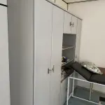 LOTE 515 - Armario de madeira, 2 macas, ar condicionado, quadro, balança, mesa e 2 cadeiras , armario portas de vidro 