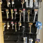 LOTE 040 - Lote com chaves combinadas, chave de boca, escova de aço, alicate, móvel expositor