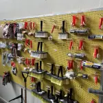 LOTE 042 - Lote com quador mostruario, silicone, linhas de nylon, serrote, martelo, disco de corte, pedra para retificas, regua, tesourão, mostra de modelos de parafusos, pedras de afiar, tampa de vaso, adaptador de mangueira, torneiras, trincha, rolo de pintura, capacetes de epi, oculos. 