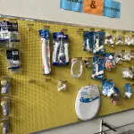 LOTE 042 - Lote com quador mostruario, silicone, linhas de nylon, serrote, martelo, disco de corte, pedra para retificas, regua, tesourão, mostra de modelos de parafusos, pedras de afiar, tampa de vaso, adaptador de mangueira, torneiras, trincha, rolo de pintura, capacetes de epi, oculos. 
