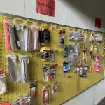 LOTE 042 - Lote com quador mostruario, silicone, linhas de nylon, serrote, martelo, disco de corte, pedra para retificas, regua, tesourão, mostra de modelos de parafusos, pedras de afiar, tampa de vaso, adaptador de mangueira, torneiras, trincha, rolo de pintura, capacetes de epi, oculos. 