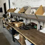 LOTE 040 - Bancada com esmeril, carregadores de baterias, furadeiras 