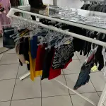 LOTE 000 - Lote com aproximadamente 3.500 peças de roupas e seus cabides (toda a loja): vestidos, saias, moletons, casacos, bermudas, calças, camisetas