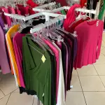 LOTE 000 - Lote com aproximadamente 3.500 peças de roupas e seus cabides (toda a loja): vestidos, saias, moletons, casacos, bermudas, calças, camisetas