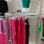 LOTE 000 - Lote com aproximadamente 3.500 peças de roupas e seus cabides (toda a loja): vestidos, saias, moletons, casacos, bermudas, calças, camisetas