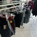 LOTE 000 - Lote com aproximadamente 3.500 peças de roupas e seus cabides (toda a loja): vestidos, saias, moletons, casacos, bermudas, calças, camisetas