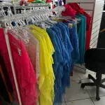 LOTE 000 - Lote com aproximadamente 3.500 peças de roupas e seus cabides (toda a loja): vestidos, saias, moletons, casacos, bermudas, calças, camisetas
