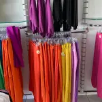 LOTE 000 - Lote com aproximadamente 3.500 peças de roupas e seus cabides (toda a loja): vestidos, saias, moletons, casacos, bermudas, calças, camisetas